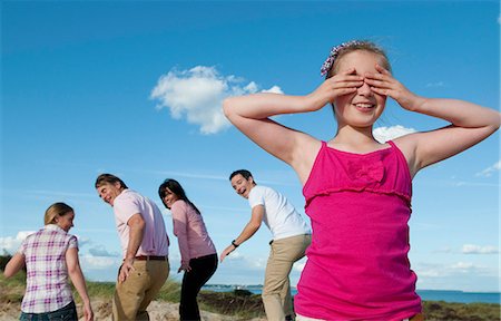 family and friends - Family playing hide and seek outdoors Stock Photo - Premium Royalty-Free, Code: 649-06433491