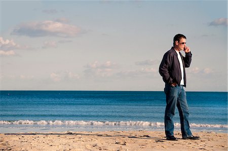 dorset - Man talking on cell phone on beach Foto de stock - Sin royalties Premium, Código: 649-06433538