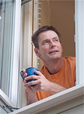 simsearch:632-07674627,k - Man with coffee leaning out window Stock Photo - Premium Royalty-Free, Code: 649-06433541