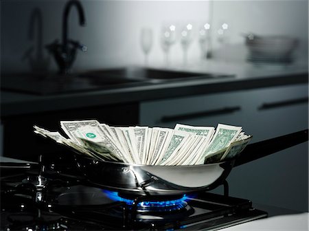 Dollar bills in frying pan on stove Stock Photo - Premium Royalty-Free, Code: 649-06433636