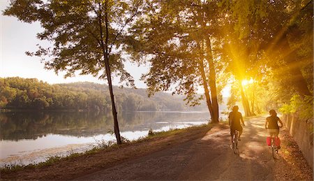 europe travelling - Couple riding bicycles by river bank Stock Photo - Premium Royalty-Free, Code: 649-06433680