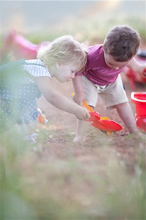 pá de jardim - Toddlers playing together on dirt road Foto de stock - Royalty Free Premium, Número: 649-06488449