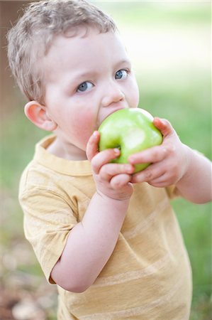Boy eating apple outdoors Stock Photo - Premium Royalty-Free, Code: 649-06488452