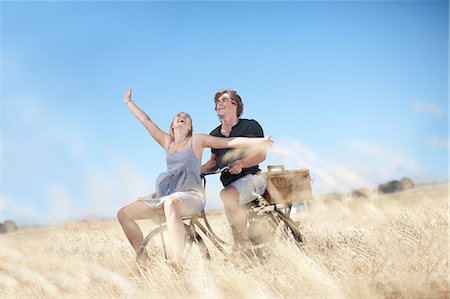 simsearch:649-03881502,k - Couple riding bicycle in tall grass Photographie de stock - Premium Libres de Droits, Code: 649-06488514