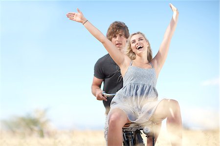 Couple riding bicycle in tall grass Stock Photo - Premium Royalty-Free, Code: 649-06488516