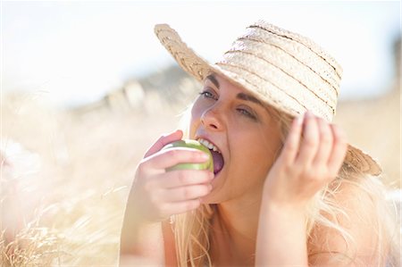 Woman eating apple in tall grass Stock Photo - Premium Royalty-Free, Code: 649-06488527