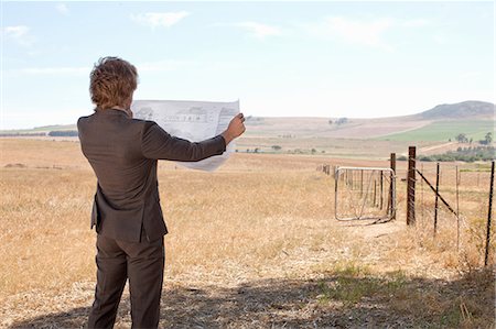 suit field - Businessman reading blueprints in field Stock Photo - Premium Royalty-Free, Code: 649-06488561