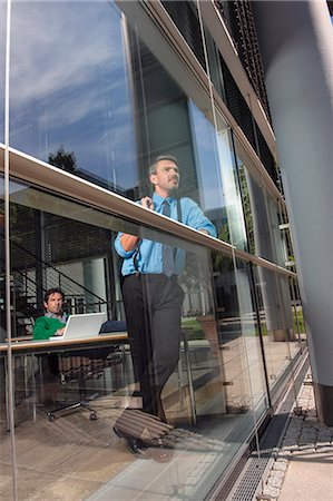 Businessmen in office behind window Photographie de stock - Premium Libres de Droits, Code: 649-06488665