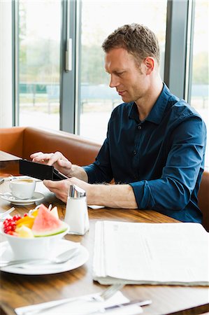 simsearch:649-06352545,k - Businessman working in cafe Stock Photo - Premium Royalty-Free, Code: 649-06488876