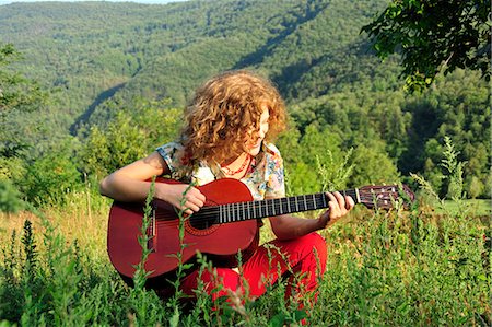 Woman playing guitar in grassy field Photographie de stock - Premium Libres de Droits, Code: 649-06488968
