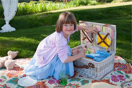 simsearch:6122-08229458,k - Girl unpacking picnic basket in field Foto de stock - Royalty Free Premium, Número: 649-06489016