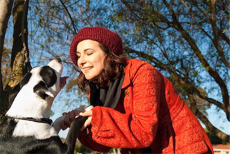 dog look up person - Woman shaking dogs paws outdoors Stock Photo - Premium Royalty-Free, Code: 649-06489057