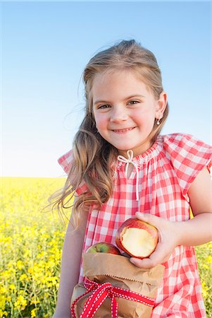 Girl eating sack of apples outdoors Stock Photo - Premium Royalty-Free, Code: 649-06489070