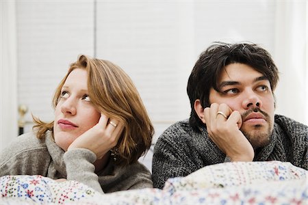 Couple resting chins in hands on bed Foto de stock - Sin royalties Premium, Código: 649-06489376