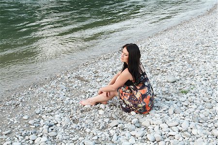 Woman sitting on rocky beach Stock Photo - Premium Royalty-Free, Code: 649-06489429