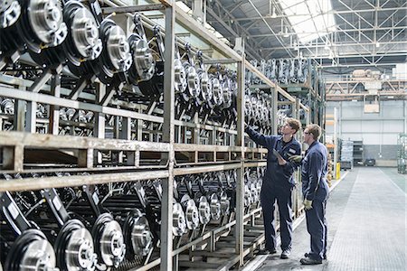 planta automatizada - Workers inspecting axles in car factory Foto de stock - Sin royalties Premium, Código: 649-06489495