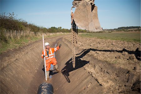 Worker directing digger in surface mine Photographie de stock - Premium Libres de Droits, Code: 649-06489584