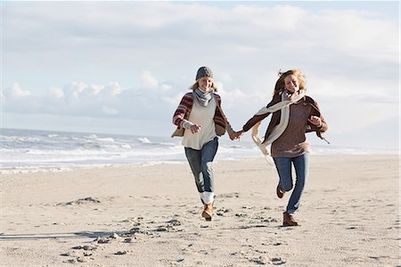 same sex couple (female) - Smiling women running on beach Stock Photo - Premium Royalty-Free, Code: 649-06489712