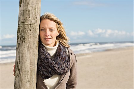 simsearch:649-06489730,k - Woman leaning on pole on beach Photographie de stock - Premium Libres de Droits, Code: 649-06489736