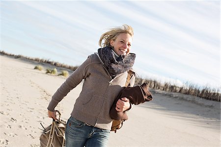 smiling in the wind with scarf - Smiling woman walking on beach Stock Photo - Premium Royalty-Free, Code: 649-06489758