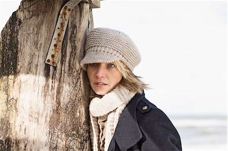 stacking wood - Woman leaning on pole on beach Stock Photo - Premium Royalty-Free, Code: 649-06489768