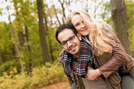 piggy back men - Man carrying girlfriend in forest Stock Photo - Premium Royalty-Free, Code: 649-06489786