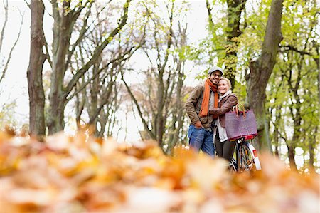 simsearch:6113-06721174,k - Couple hugging by bicycle in forest Stock Photo - Premium Royalty-Free, Code: 649-06489812