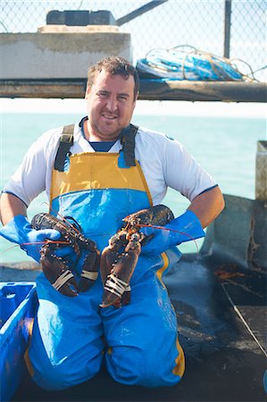 pescador (hombre y mujer) - Fisherman holding lobsters on boat Foto de stock - Sin royalties Premium, Código: 649-06489866