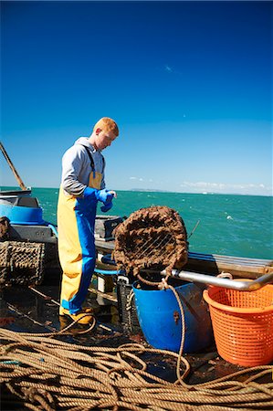 Fisherman at work on boat Foto de stock - Royalty Free Premium, Número: 649-06489861