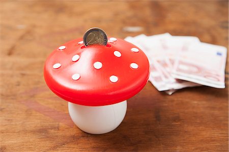saving for a rainy day - Close up of mushroom savings bank Stock Photo - Premium Royalty-Free, Code: 649-06490050
