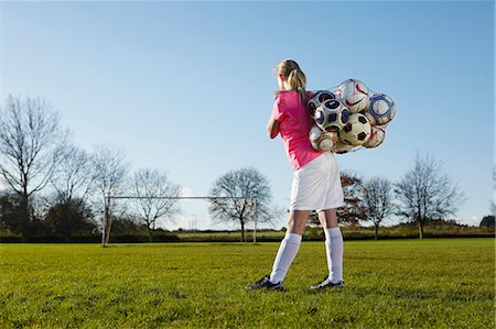 football player backview - Football player carrying balls in field Stock Photo - Premium Royalty-Free, Code: 649-06490134