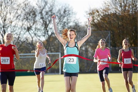 runners crossing the finish line - Runner crossing finish line in field Stock Photo - Premium Royalty-Free, Code: 649-06490132