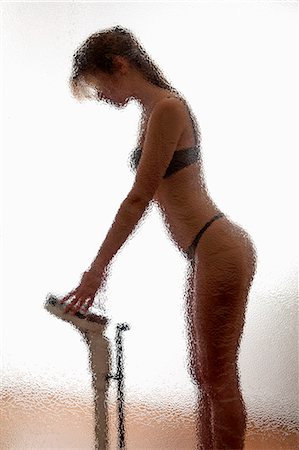 pesandose - Woman weighing herself in bathroom Foto de stock - Sin royalties Premium, Código: 649-06532557