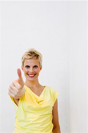 Smiling woman giving 'thumbs up Photographie de stock - Premium Libres de Droits, Code: 649-06532717