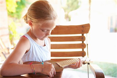 Girl strumming ukulele outdoors Stock Photo - Premium Royalty-Free, Code: 649-06532790