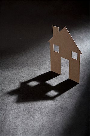 Cardboard house shape casting shadow Photographie de stock - Premium Libres de Droits, Code: 649-06532934