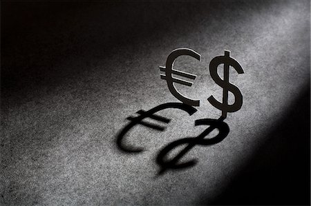 Metal currency signs casting shadow Photographie de stock - Premium Libres de Droits, Code: 649-06532932