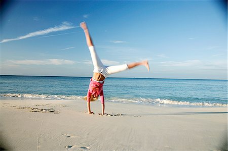 paradise island bahamas beach - Woman doing cartwheels on tropical beach Stock Photo - Premium Royalty-Free, Code: 649-06532956