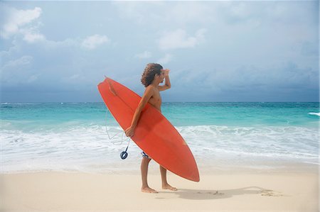 paradise island bahamas beach - Man carrying surfboard on tropical beach Stock Photo - Premium Royalty-Free, Code: 649-06533000