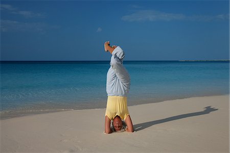 senior woman exercising by ocean - Woman practicing yoga on tropical beach Stock Photo - Premium Royalty-Free, Code: 649-06533003