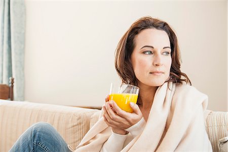 food sofa - Woman having cup of juice on sofa Foto de stock - Sin royalties Premium, Código: 649-06533054