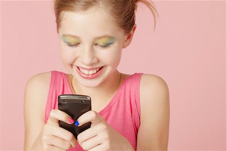 Girl in colorful makeup using cell phone Stock Photo - Premium Royalty-Free, Code: 649-06533097