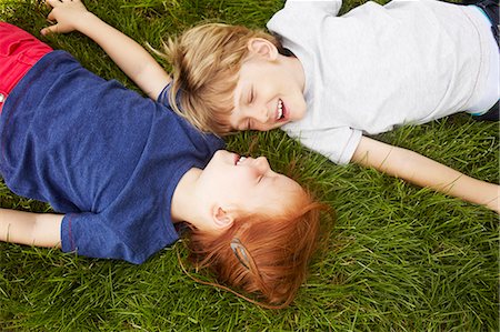 Smiling children laying in grass together Stock Photo - Premium Royalty-Free, Code: 649-06533110