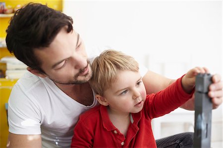 parents and kids working together - Father and son building with blocks Stock Photo - Premium Royalty-Free, Code: 649-06533335