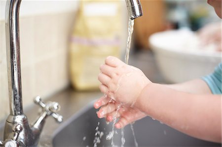 reinigen - Girl washing her hands in kitchen Photographie de stock - Premium Libres de Droits, Code: 649-06533344