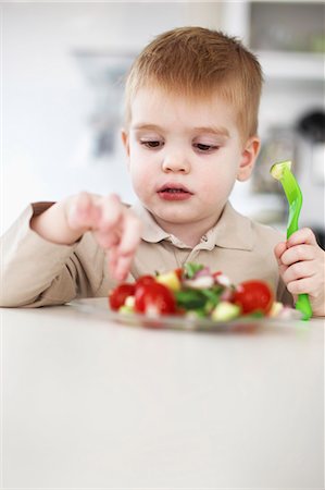 people in russia - Boy picking at plate of fruit in kitchen Stock Photo - Premium Royalty-Free, Code: 649-06533358