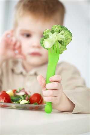 Boy examining forkful of broccoli Foto de stock - Sin royalties Premium, Código: 649-06533359