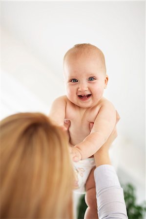 diaper kid pictures - Mother holding laughing baby girl Foto de stock - Sin royalties Premium, Código: 649-06533383