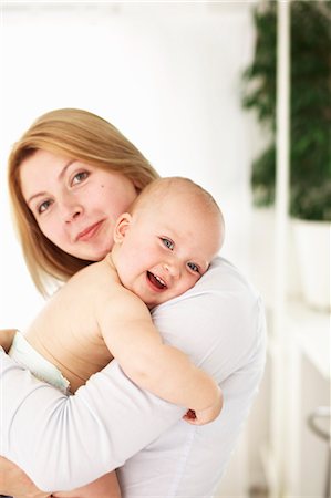 diapering mother to baby - Smiling mother holding baby girl Photographie de stock - Premium Libres de Droits, Code: 649-06533393