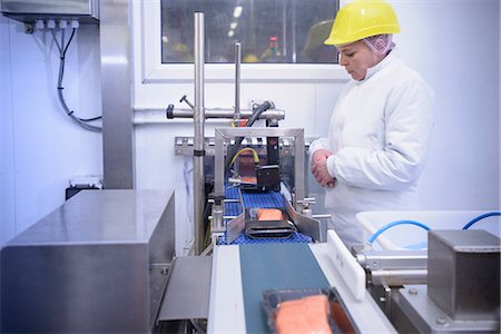 sûreté - Worker packing fish filets in factory Photographie de stock - Premium Libres de Droits, Code: 649-06533408